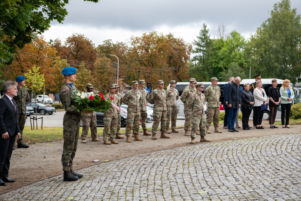Polish Soldier holds wreath at monument