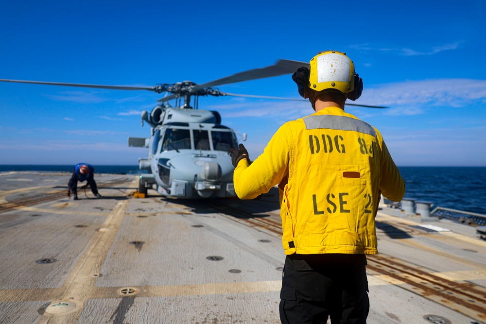 BM3 Carlens Milice and BM1 Jason Carpenter prepare an MH-60R Seahawk for take-off during the Northern Coasts 2025