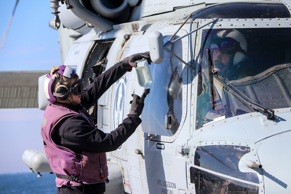 GSM2 Mark Bacca presents a fuel sample to pilot Lt. Michael Cross during the Northern Coasts 2025
