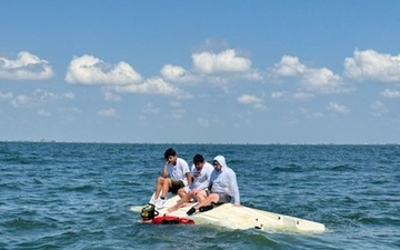 Coast Guard Rescue Swimmer Approaches Boaters Who's Vessel Capsized