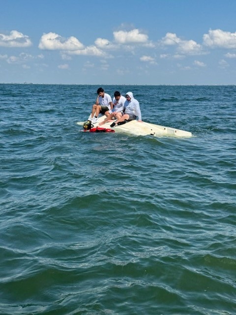Coast Guard Rescue Swimmer Approaches Boaters Who's Vessel Capsized