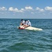 Coast Guard Rescue Swimmer Approaches Boaters Who's Vessel Capsized