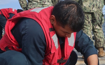 SR Freddy Climaco unfastens the pilot ladder to receive a small boat personnel transfer during NoCo25