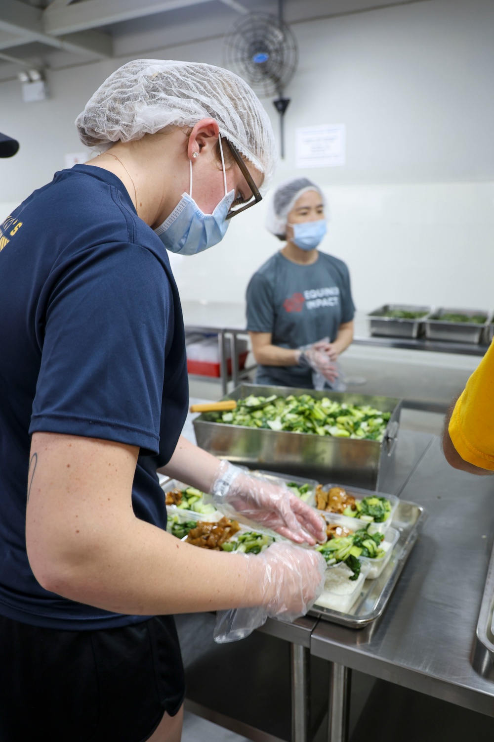 USS Frank Cable (AS 40) Sailors assemble lunches at Singapore soup kitchen