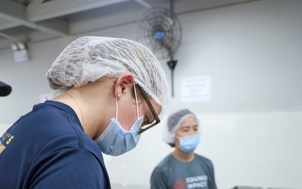 USS Frank Cable (AS 40) Sailors assemble lunches at Singapore soup kitchen