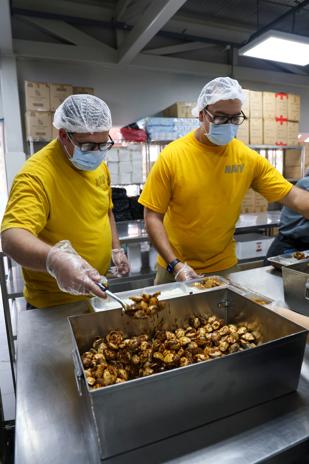 USS Frank Cable (AS 40) Sailors assemble lunches at Singapore soup kitchen