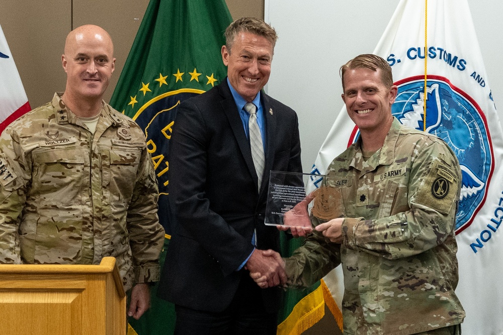 Customs and Border Protection Commissioner Rodney Scott presents a placard of appreciation to Lieutenant Colonel Matthew S. Bauer, commander of Fort A.P. Hill