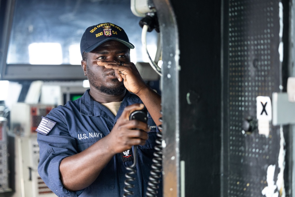 USS Curtis Wilbur (DDG 54) Sailor Conducts Boatswain's Pipe Call