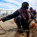 STG3 Abalos Axlross and STGSN Nathan Antepara stow the pilot ladder during sea-and-anchor