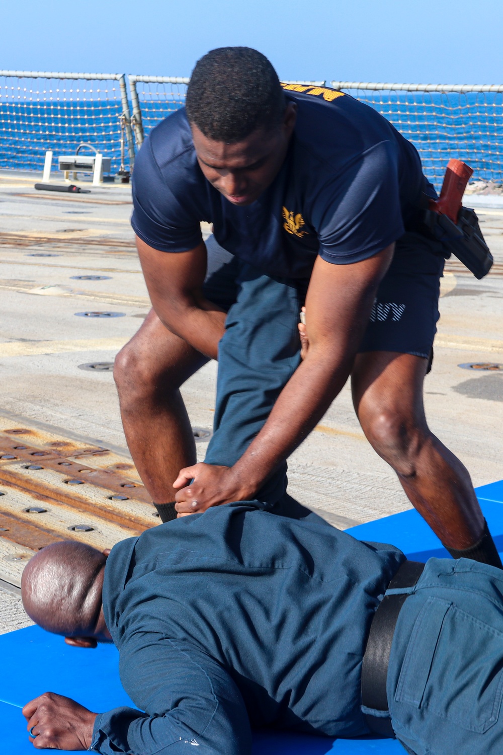 CTT1 Darren Grant and GM1 Don Dume conduct non-lethal weapons training and take down defense techniques during exercise Northern Coasts 2025