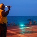 BM1 Jason Carpenter signals to pilots while a rigid-hulled inflatable boat team executes maneuvers during exercise Northern Coasts 2025