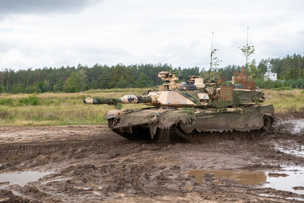 U.S. Abrams tank advances through muddy terrain at Poland's Iron Defender-25 exercise