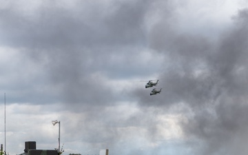 Polish soldiers take defensive positions with Hind helicopters overhead