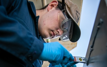USS Mitscher (DDG 57) Sailor conducts maintenance