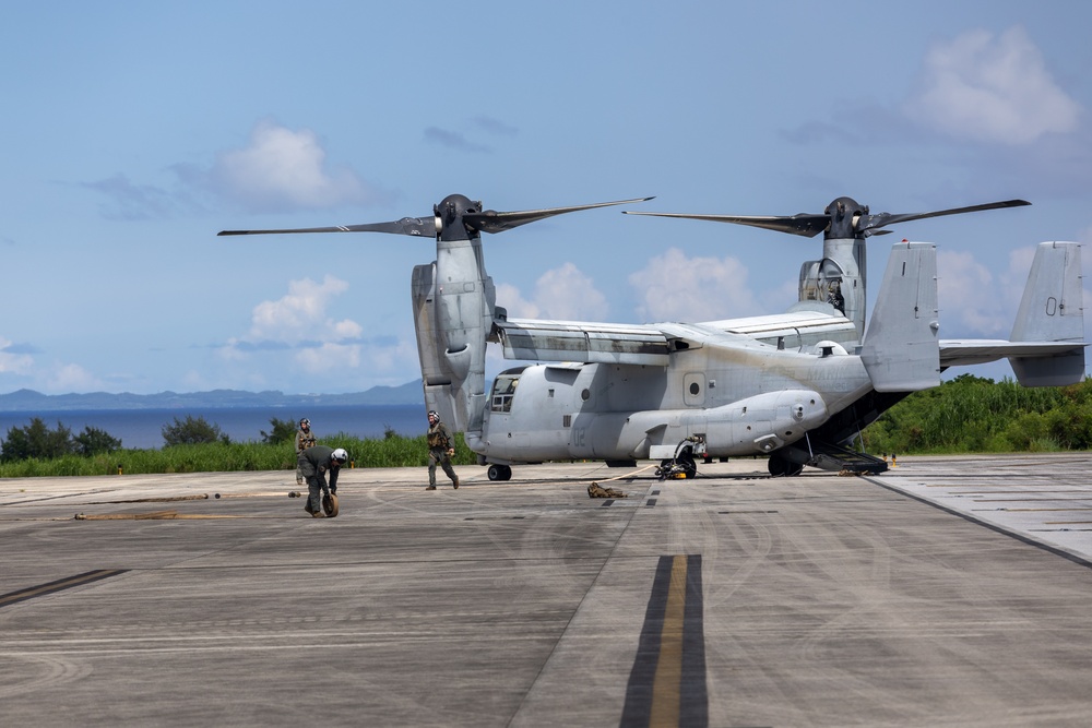U.S. Marines, Sailors, Japan Ground Self-Defense Force members refuel AH-64 Apaches with MV-22B Ospreys
