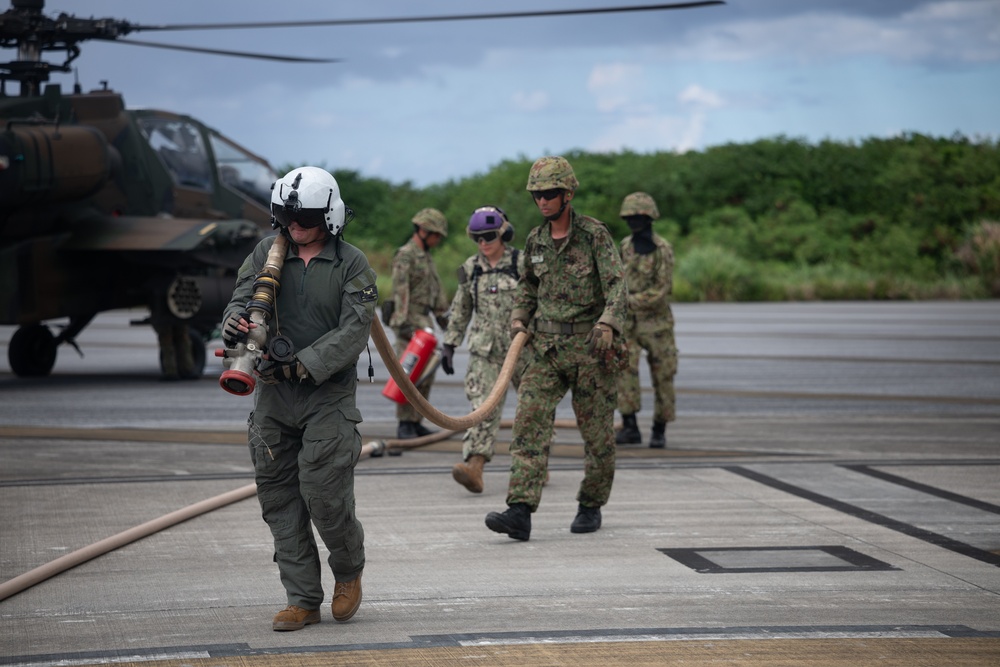 U.S. Marines, Sailors, Japan Ground Self-Defense Force members refuel AH-64 Apaches with MV-22B Ospreys
