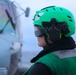 AM2 Caroline Woolley signals to pilots aboard a MH-60R, Sea Hawk helicopter