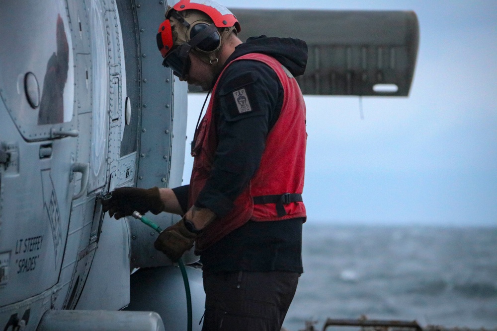 AO2 Jarrett Parker conducts an engine water wash on a MH-60R, Sea Hawk helicopter