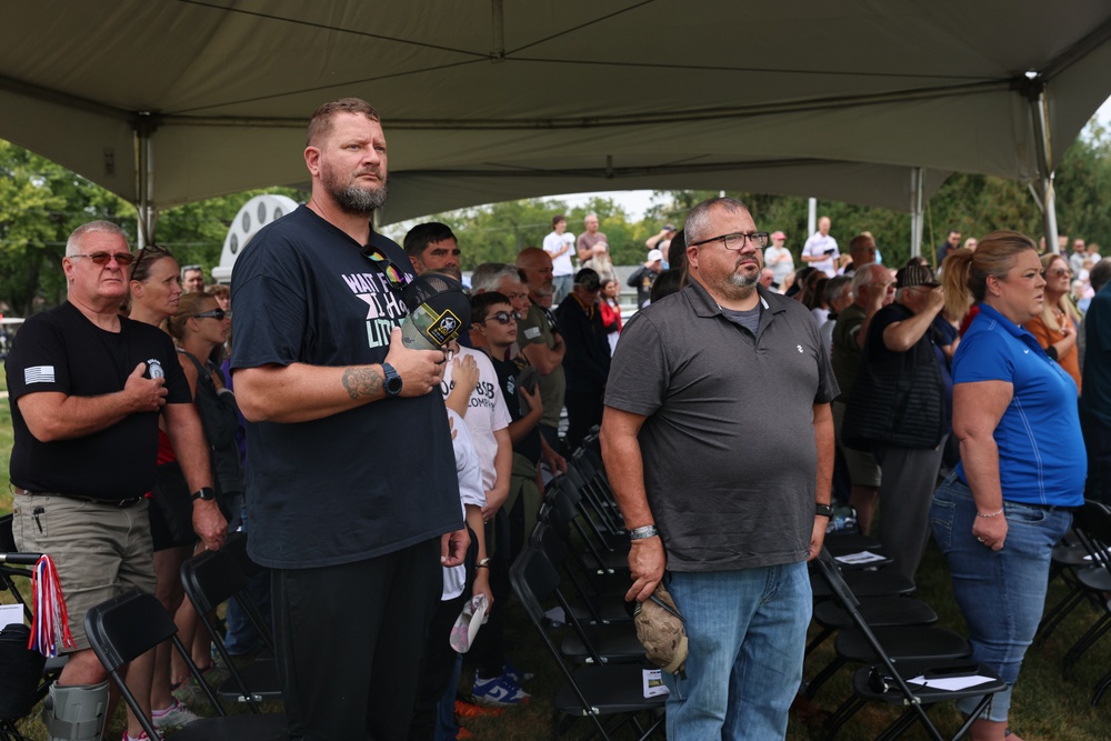 Attendees honor the flag during Pledge of Allegiance at Wall of Remembrance ceremony