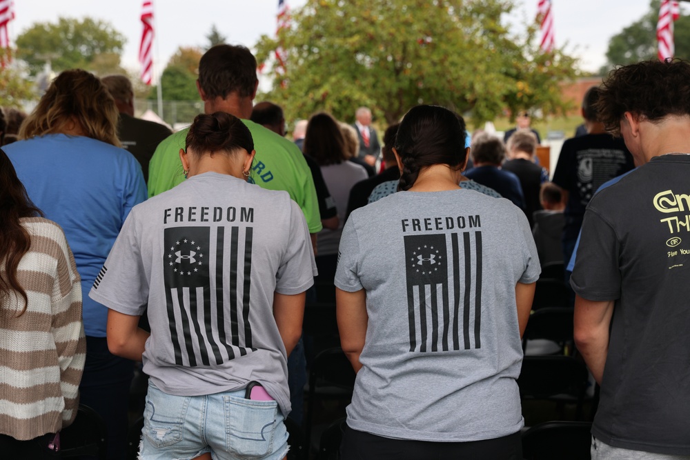 Attendees bow their heads in a moment of silence at Wall of Remembrance ceremony