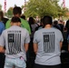 Attendees bow their heads in a moment of silence at Wall of Remembrance ceremony