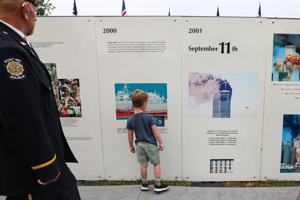 Young boy observes Global War on Terror history panels at Wall of Remembrance in Solon, Iowa
