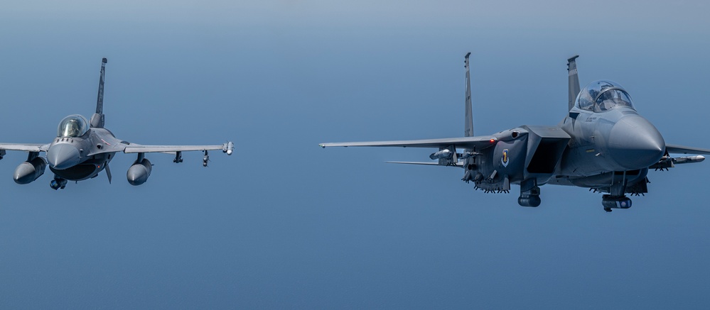 F-15EX Eagle II and F-16D Fighting Falcon fly over the Gulf of America