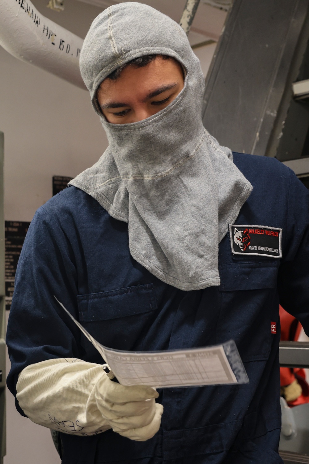 IT2 David Meehan references his zone tasking and identification card during General Quarters