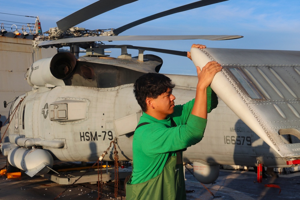 AM2 Keith Gonzales begins stowing an MH-60R Sea Hawk helicopter during the Northern Coasts
