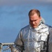 DC3 Levi Nuslein carries a pick-axe while wearing a hot suit during simulated crash and salvage training