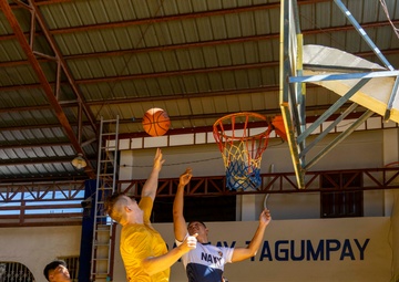 USS Frank Cable (AS 40) Sailors participate in a basketball game with Philippine sailors