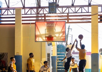 USS Frank Cable (AS 40) Sailors participate in a basketball game with Philippine sailors