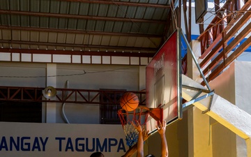 USS Frank Cable (AS 40) Sailors participate in a basketball game with Philippine sailors