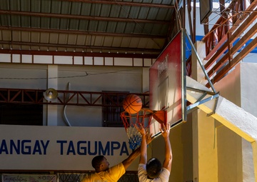 USS Frank Cable (AS 40) Sailors participate in a basketball game with Philippine sailors