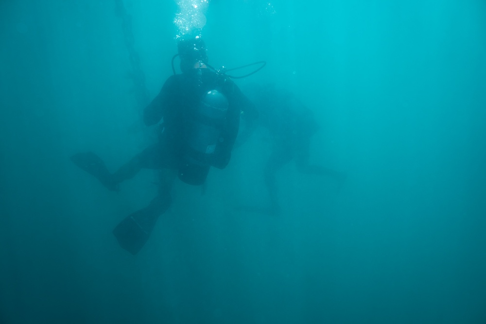 U.S. Coast Guard divers conduct aids to navigation maintenance