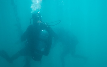 U.S. Coast Guard divers conduct aids to navigation maintenance