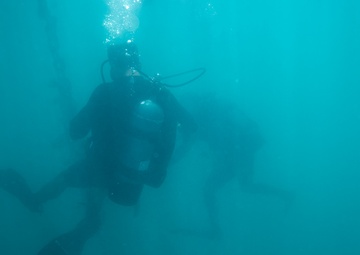 U.S. Coast Guard divers conduct aids to navigation maintenance