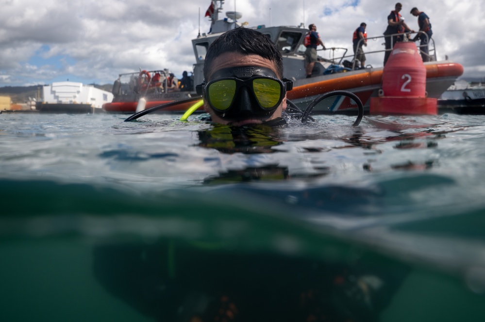 U.S. Coast Guard divers conduct aids to navigation maintenance