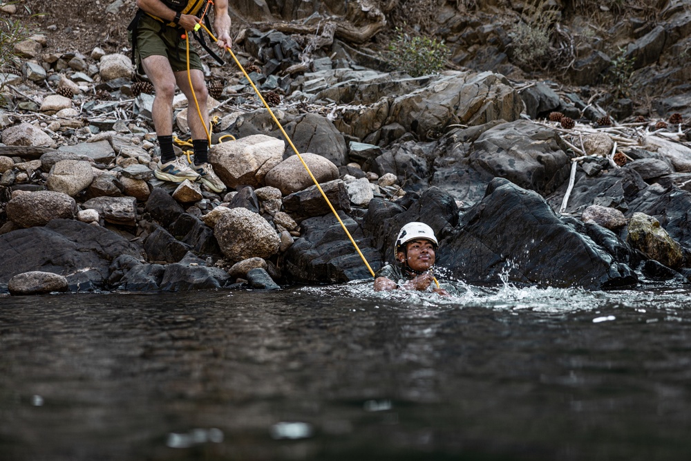 U.S. service members and German soldiers conduct stream crossing exercises during Mountain Medicine 3-25 