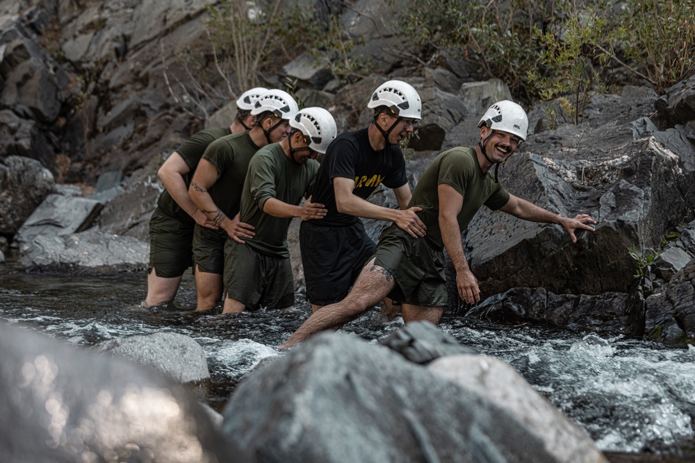 U.S. service members and German soldiers conduct stream crossing exercises during Mountain Medicine 3-25 