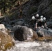 U.S. service members and German soldiers conduct stream crossing exercises during Mountain Medicine 3-25 
