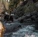 U.S. service members and German soldiers conduct stream crossing exercises during Mountain Medicine 3-25 