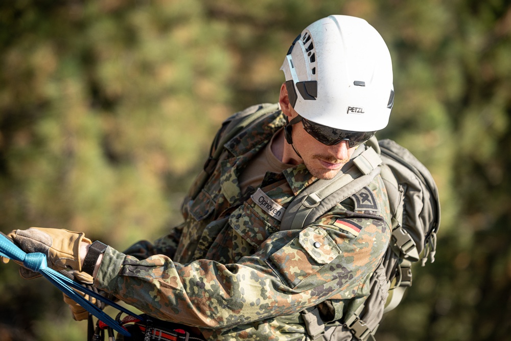 U.S. service members and German soldiers conduct repelling exercises during Mountain Medicine 3-25