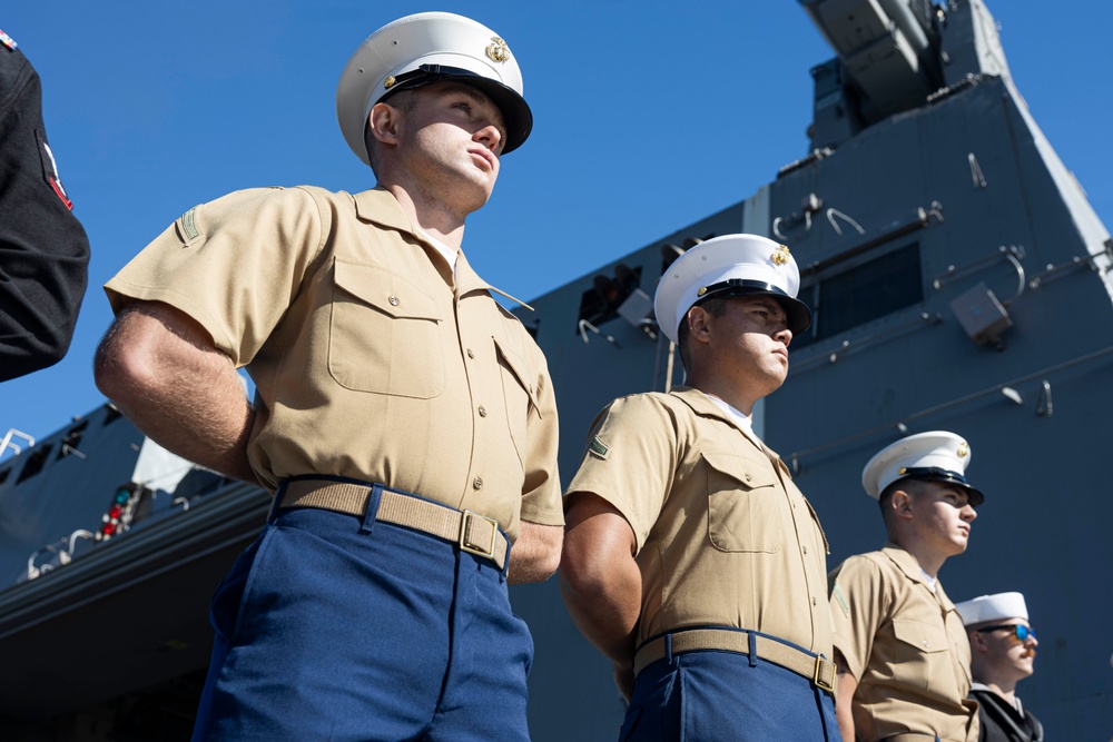 U.S. Marines and Sailors man the rails aboard the USS Arlington
