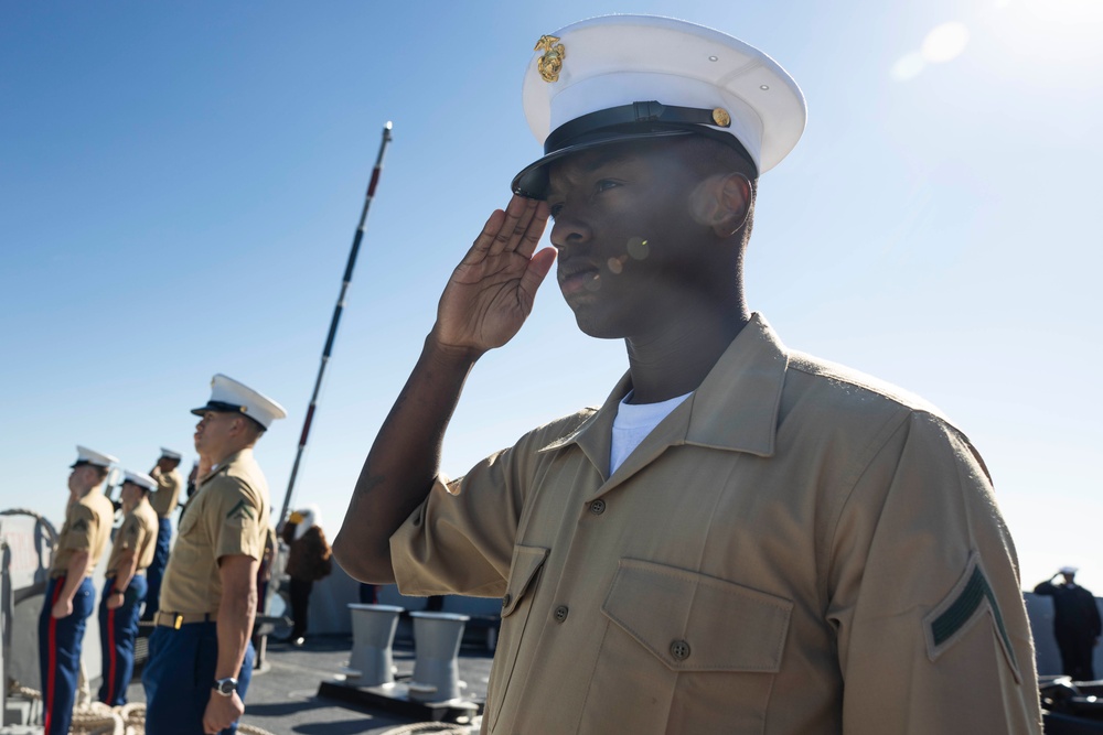 U.S. Marines and Sailors man the rails aboard the USS Arlington