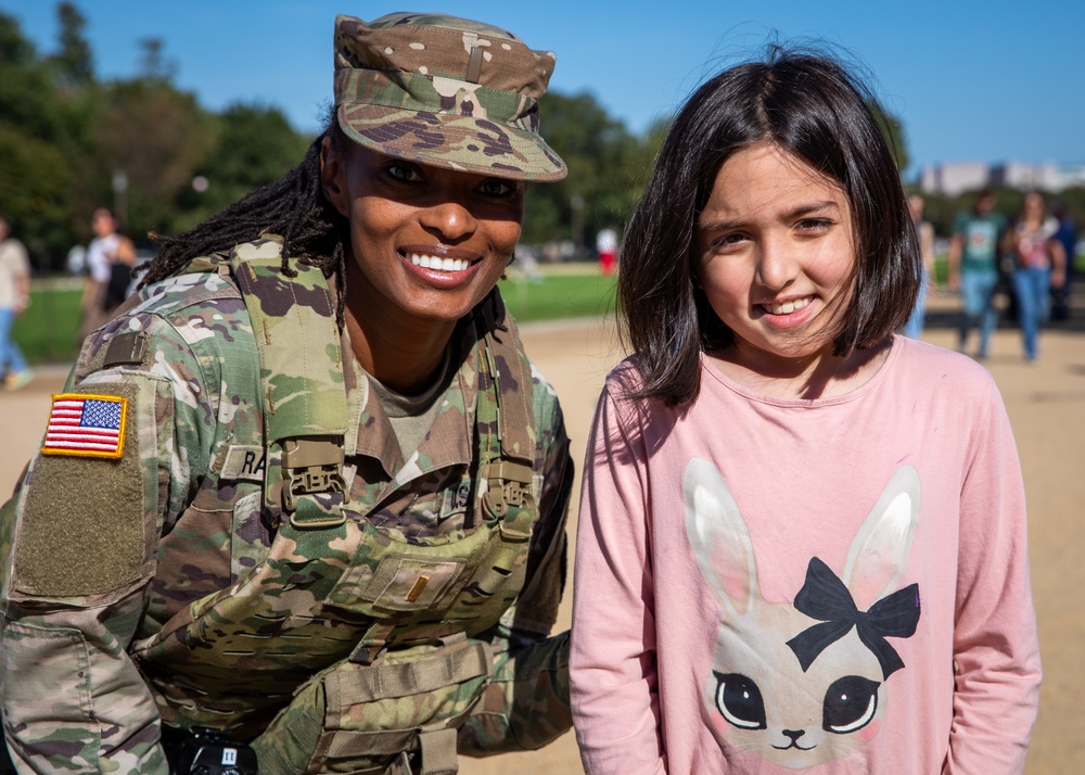 A Mississippi Army National Guard Soldier takes a photo with a civilian