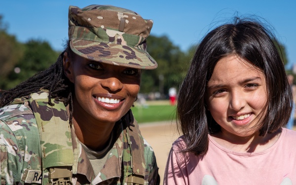A Mississippi Army National Guard Soldier takes a photo with a civilian
