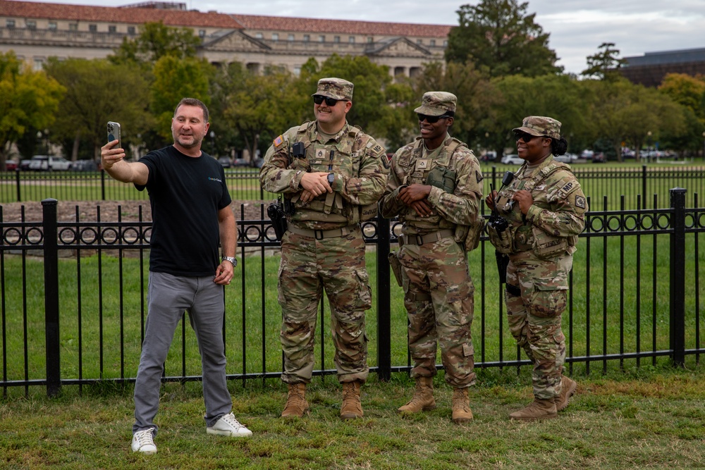 Mississippi Army National Guard Soldiers take a photo with a member of the public