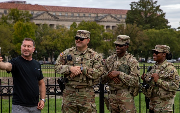 Mississippi Army National Guard Soldiers take a photo with a member of the public