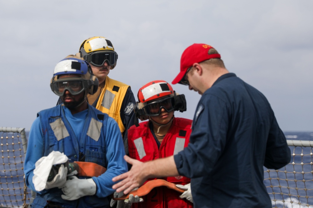 Sailors aboard the USS John Finn conduct a crash and salvage drill in the Philippine Sea
